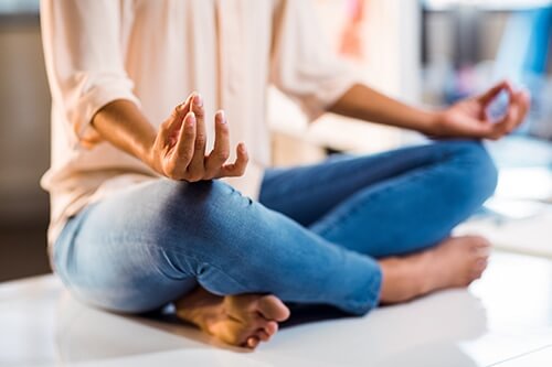 a woman meditates over the question what is yoga therapy
